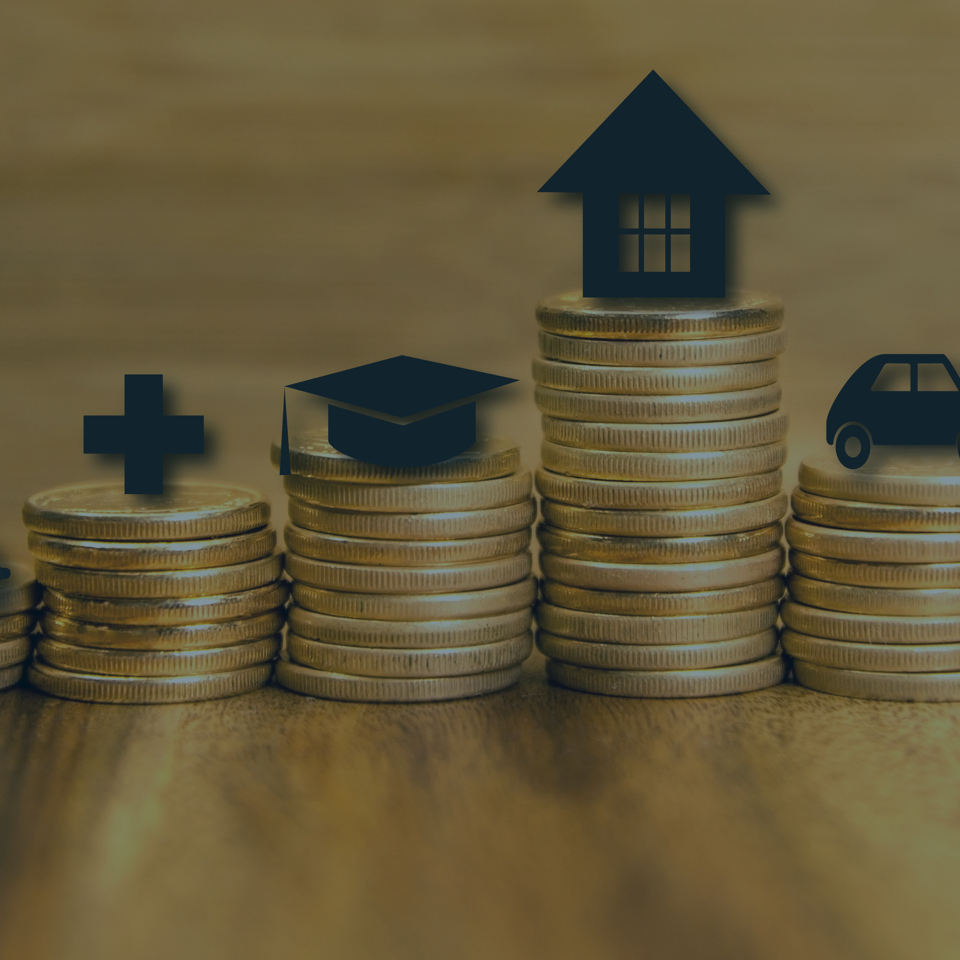 Four stacks of coins of varying heights are shown in the image. From left to right, the stacks feature a medical cross, a graduation cap, a house, and a car icon, symbolizing increasing cost priorities: healthcare, education, housing, and transportation.